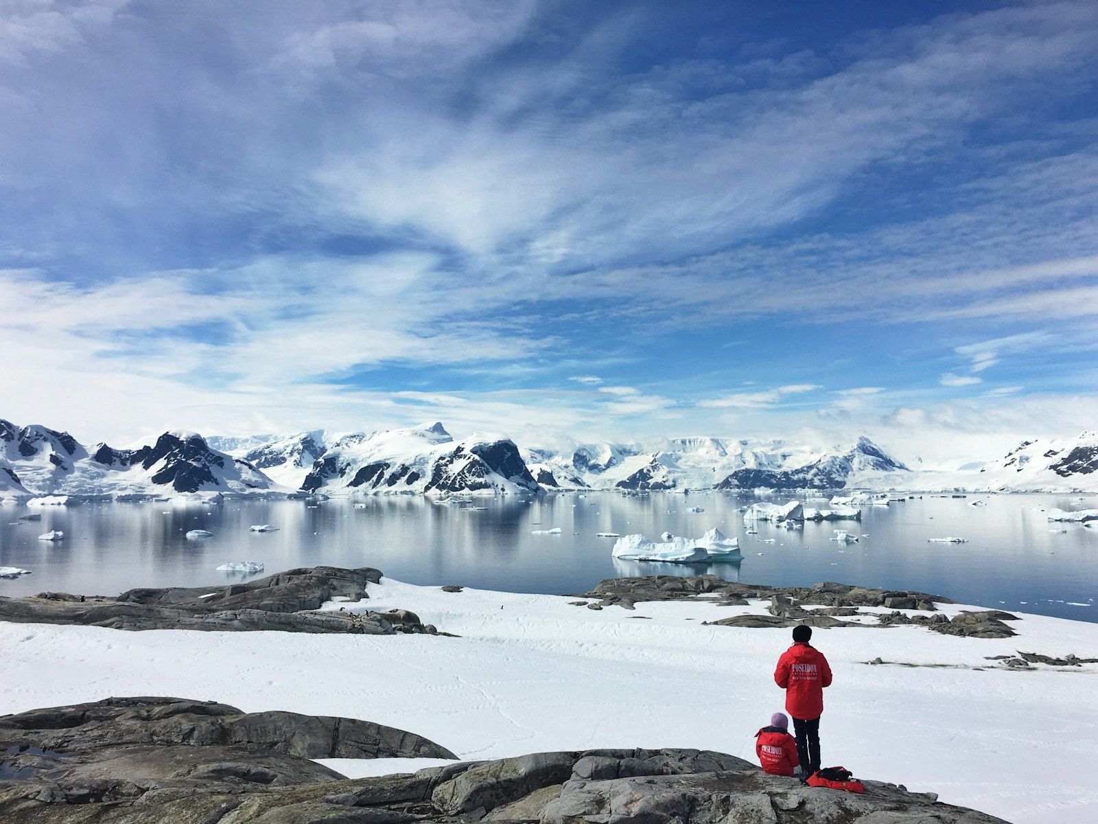 A figure in a red jacket above a polar bay