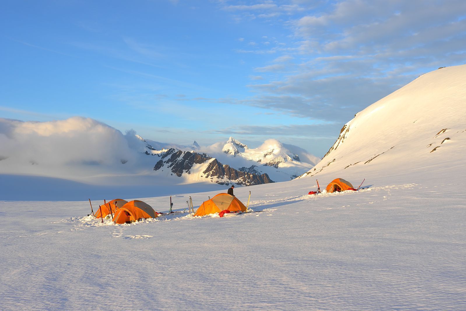 Small tents on a wide snow slope