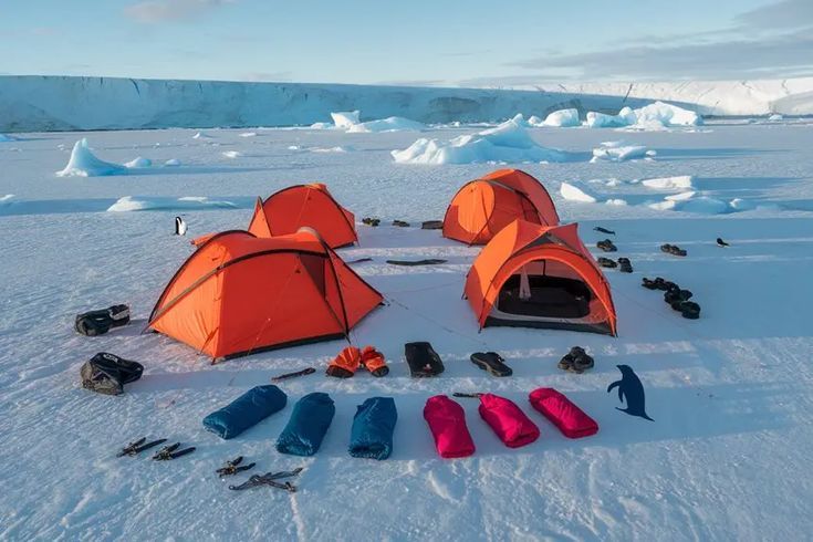 Tents and sleeping bags laid out on the snow