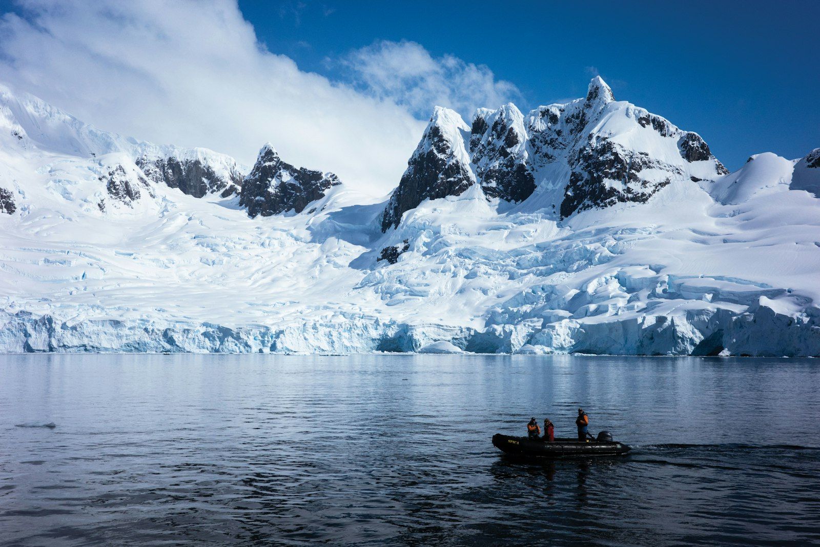 Small boat below glaciated peaks