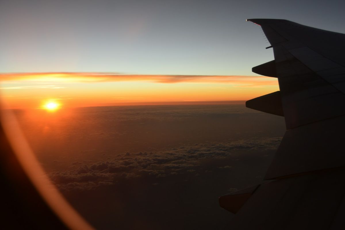 Aircraft wing silhouetted against a low sun