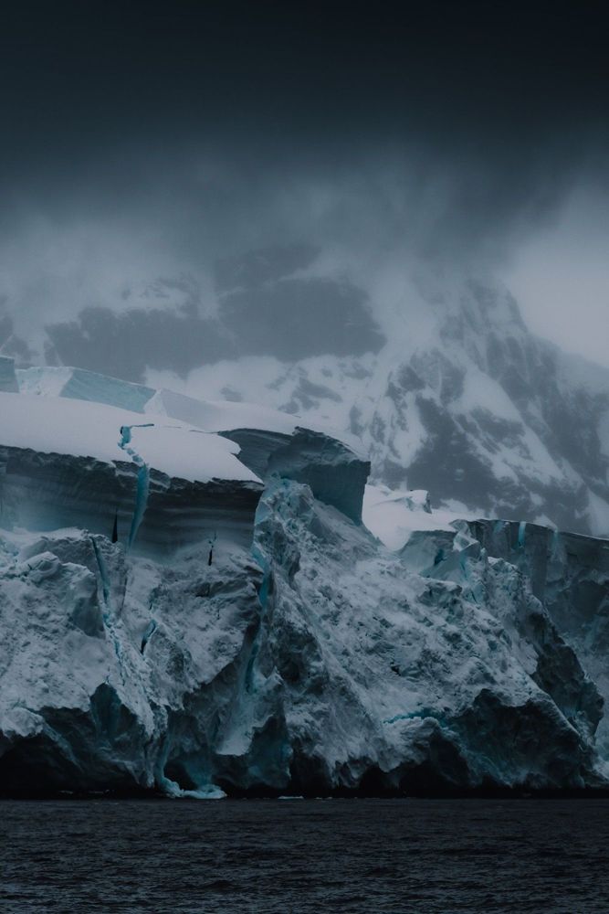 Dark ice cliff under storm cloud