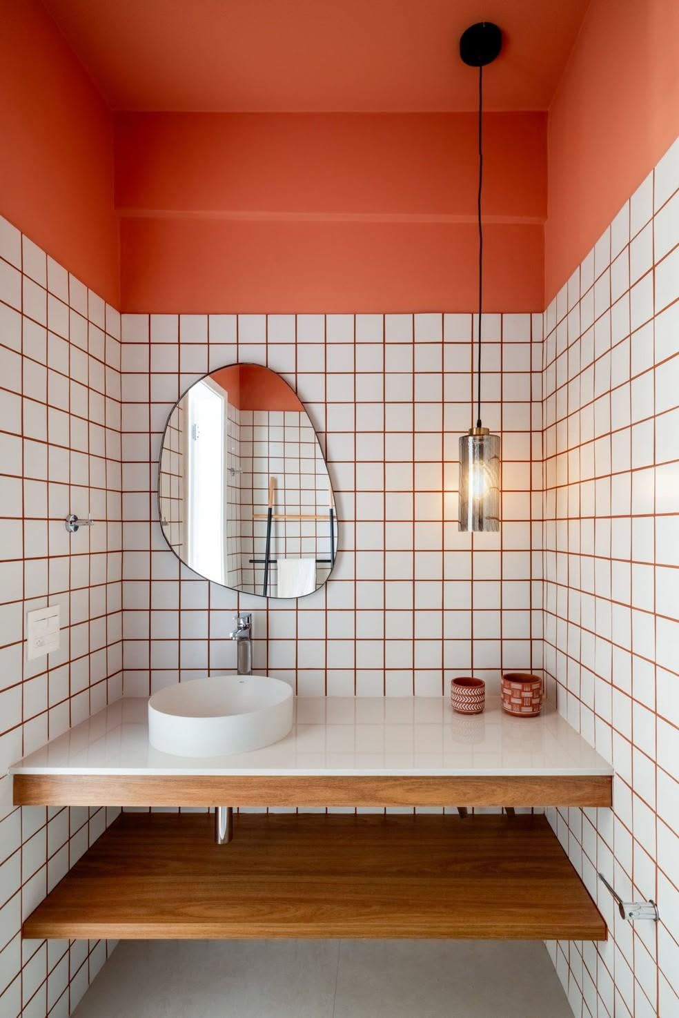 Grid-tiled washroom with an orange ceiling