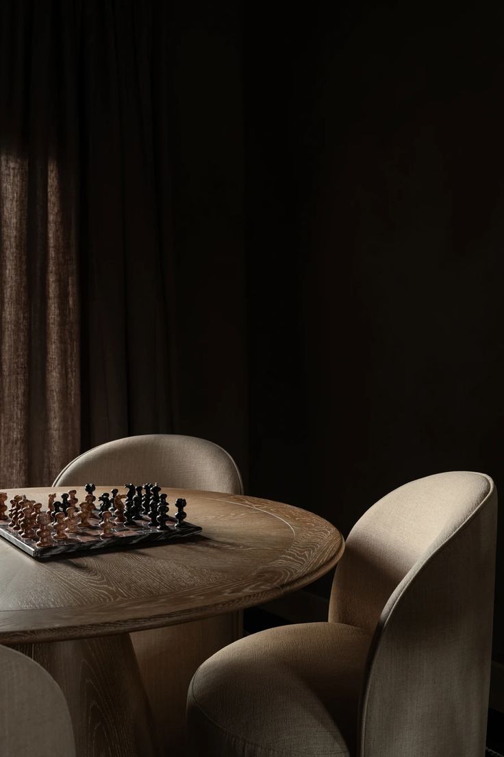 Chess set on a round table between two chairs