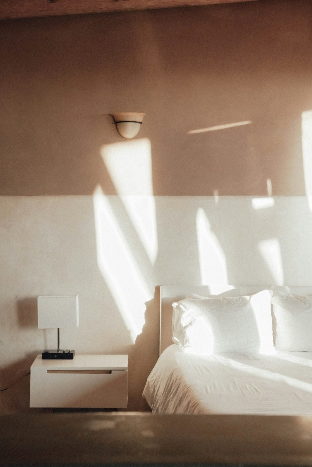 Sunlit bedroom with a white bed