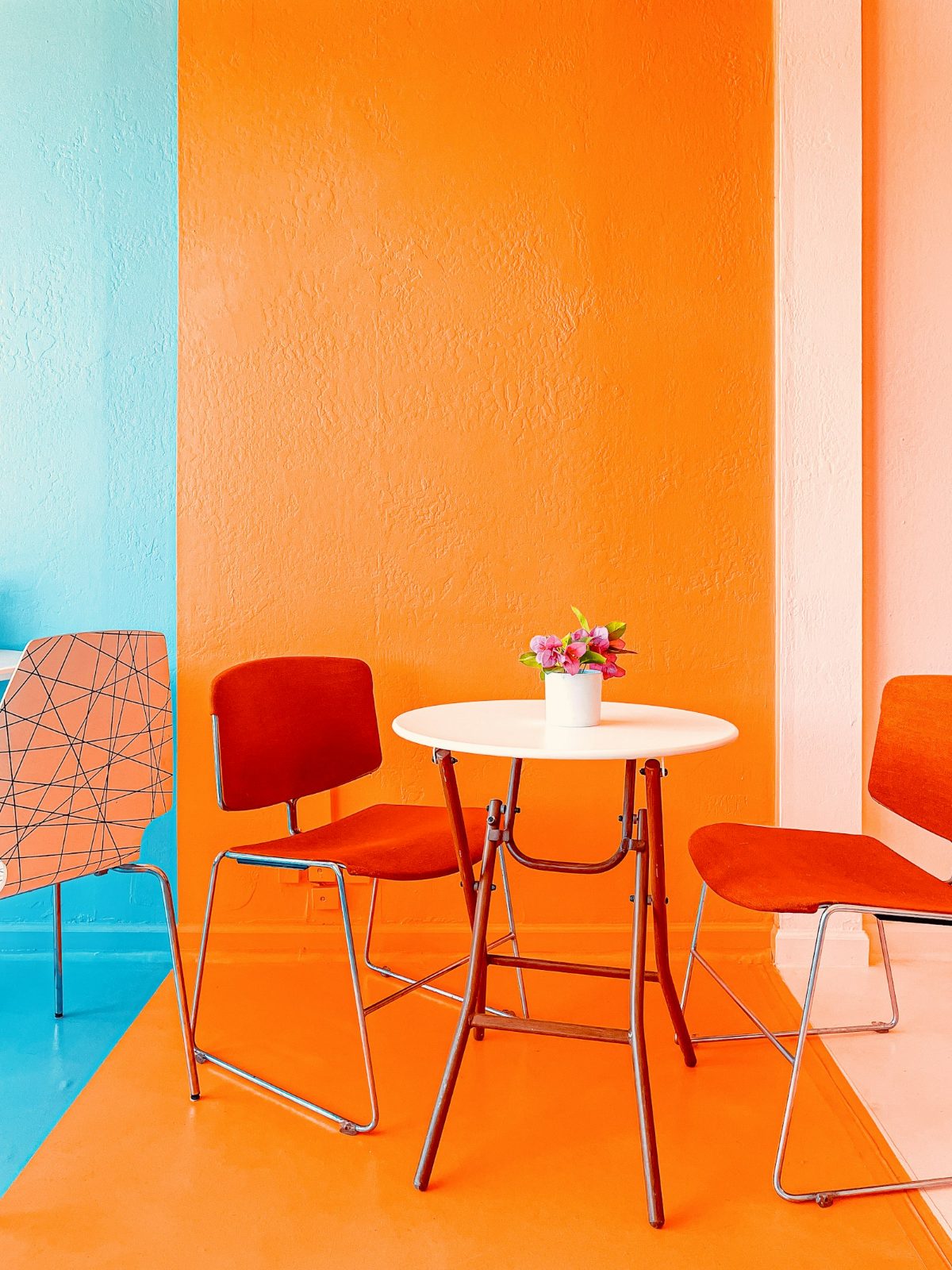 Orange room with red chairs around a small table