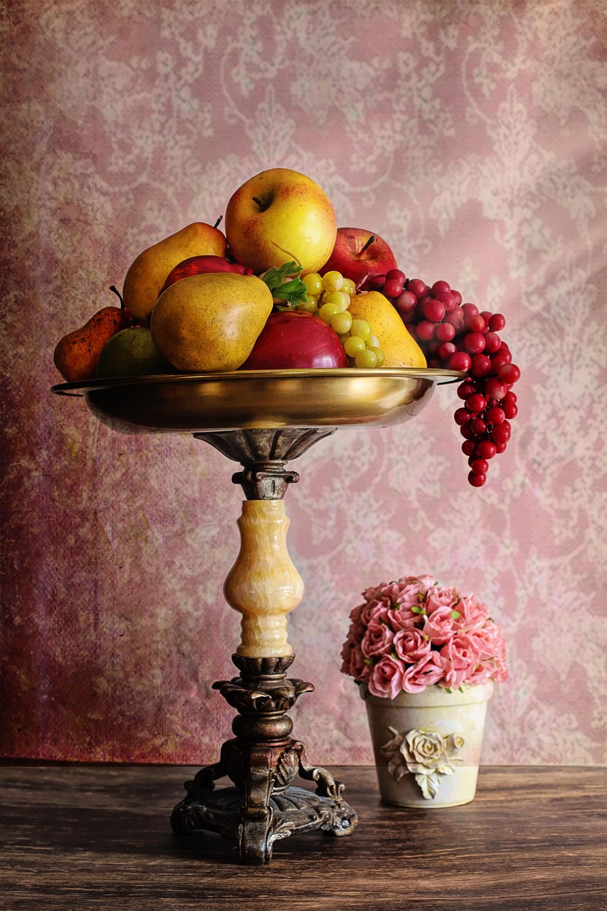 Fruit bowl on a stand against pink wallpaper
