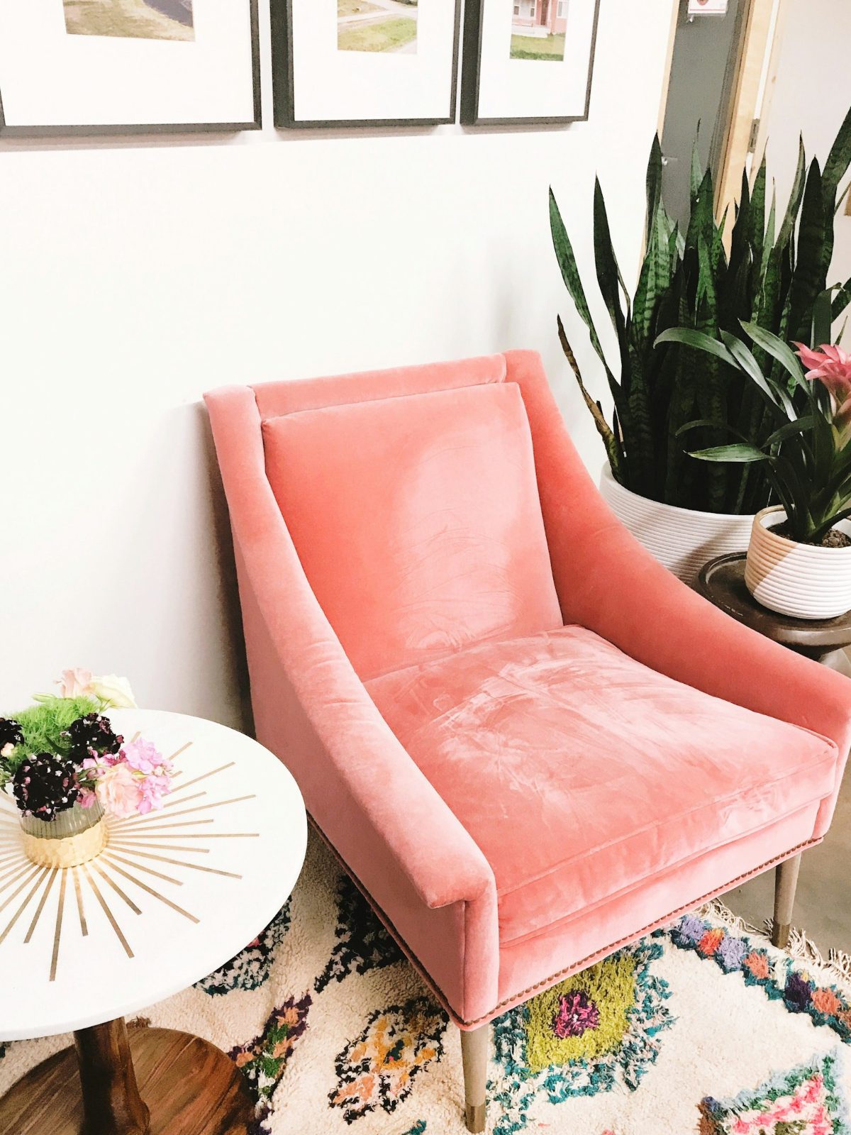 Coral velvet armchair beside a small table
