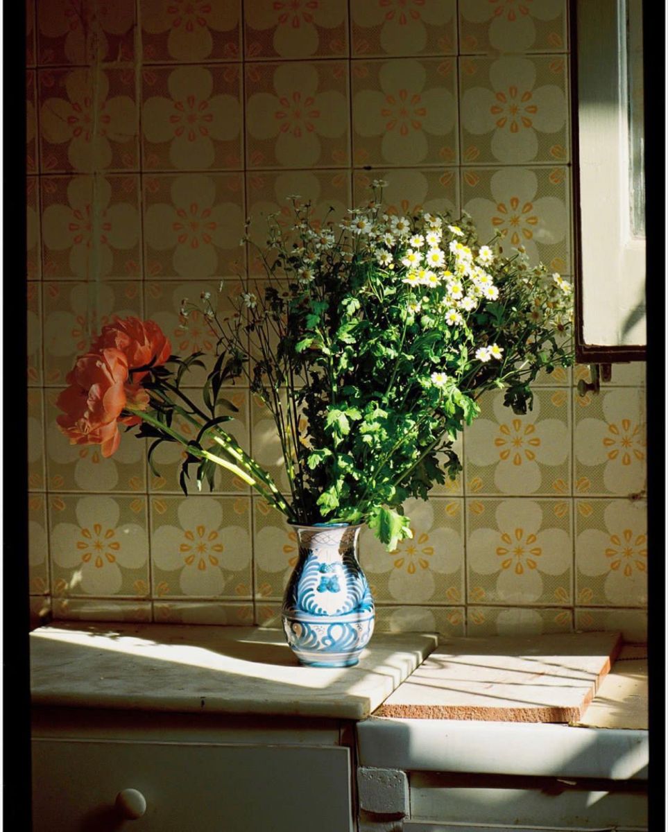 Flowers in a blue vase against patterned tile