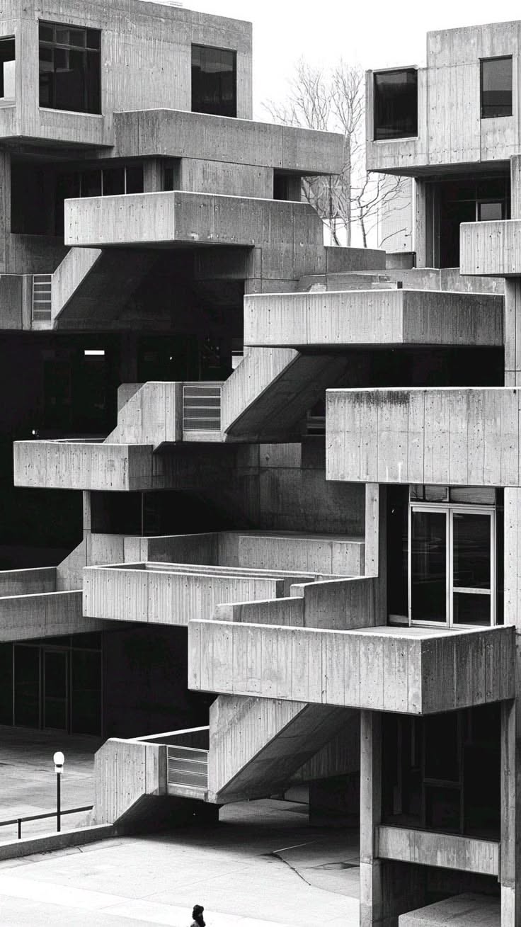 Stacked concrete housing units against a pale sky
