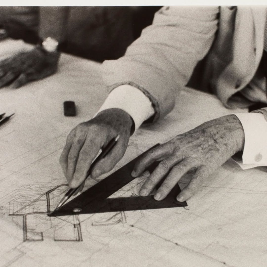 Hands, triangle and a sheet of plans