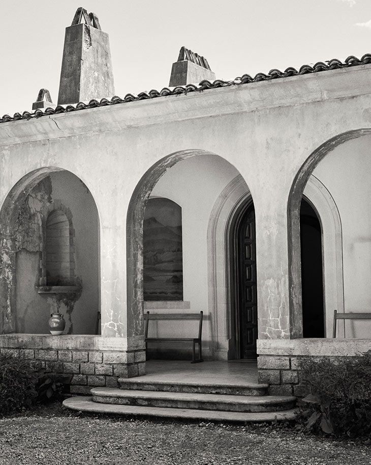 Stucco arcade with tile roof and chimneys