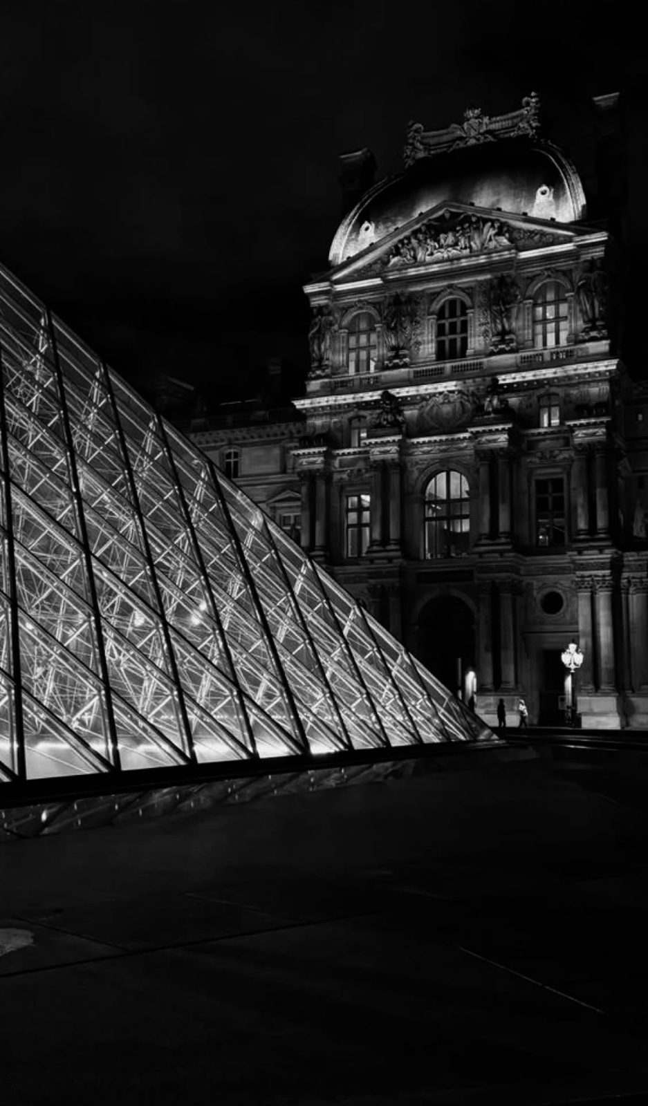 Pyramid edge and palace facade at night