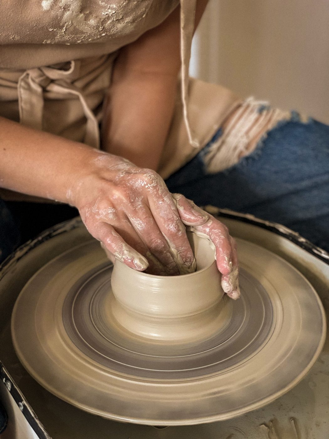 Hands inside a pot on the wheel