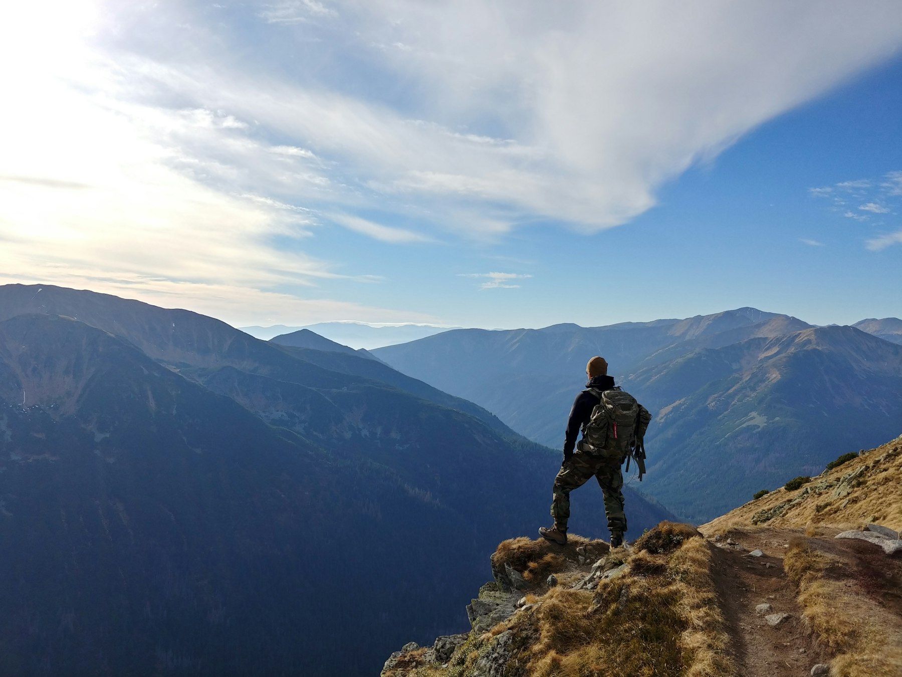 Hiker looking over blue mountain ranges