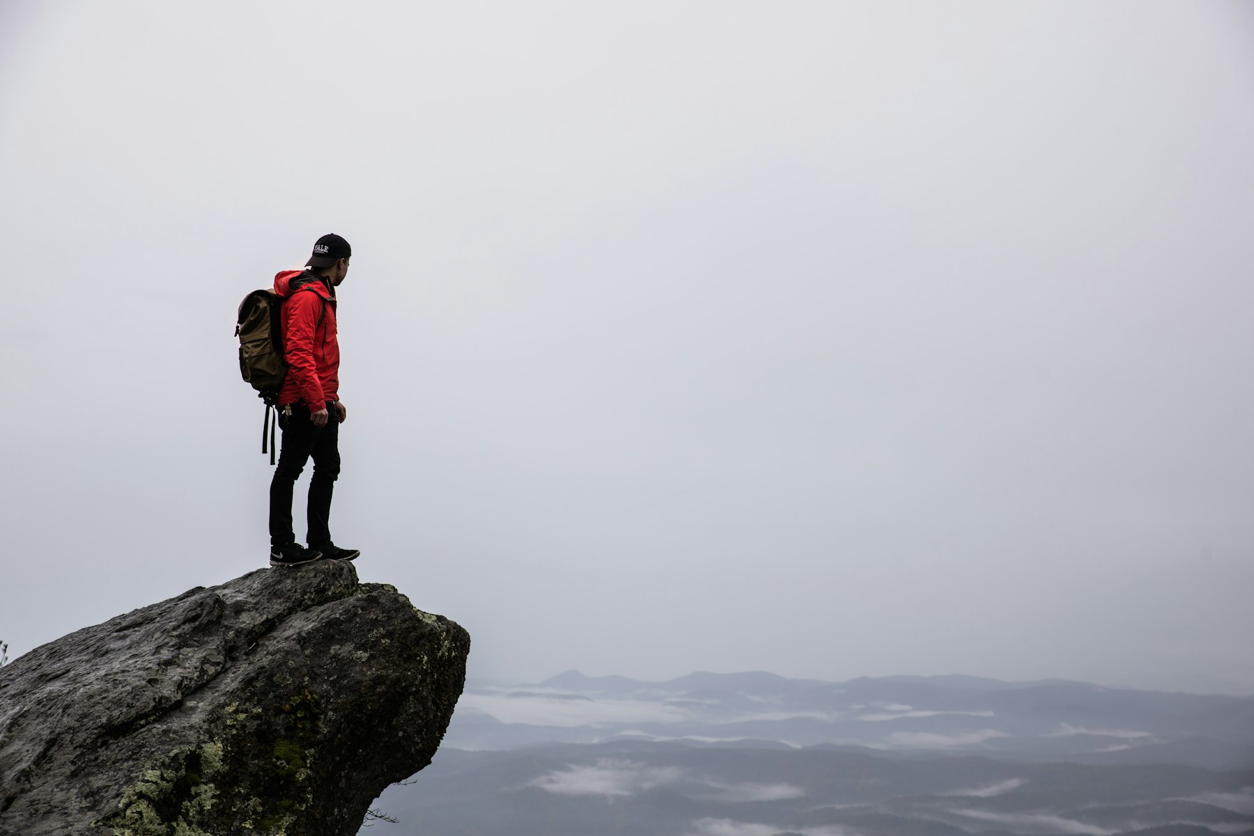 Hiker on a rock above fog