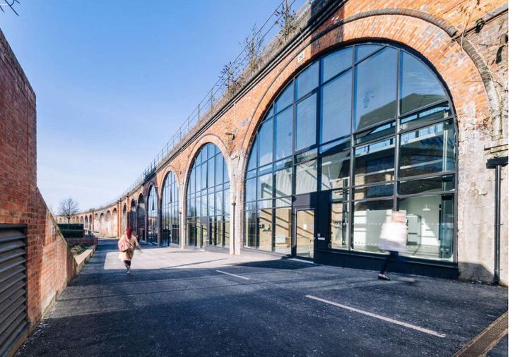 A row of glazed brick railway arches curving along an empty road