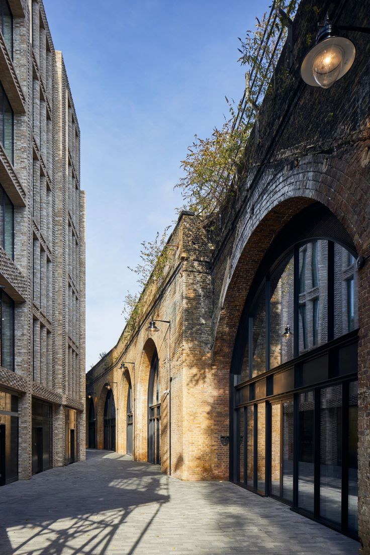 Brick railway arches with glazed fronts along a paved lane