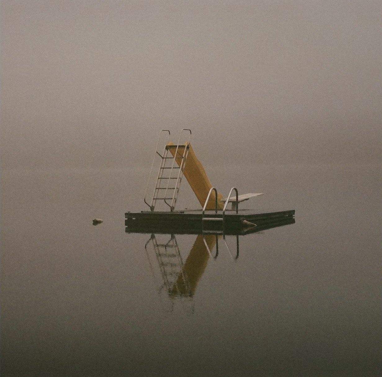 Diving platform on a still lake in morning fog