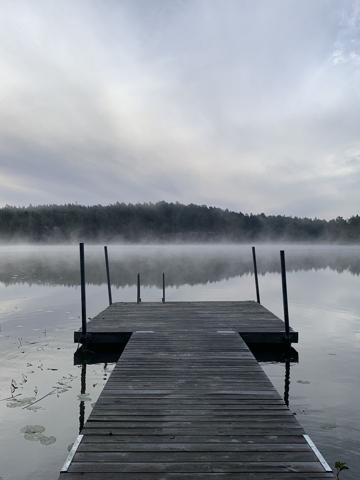 Wooden jetty into a misty lake at dawn