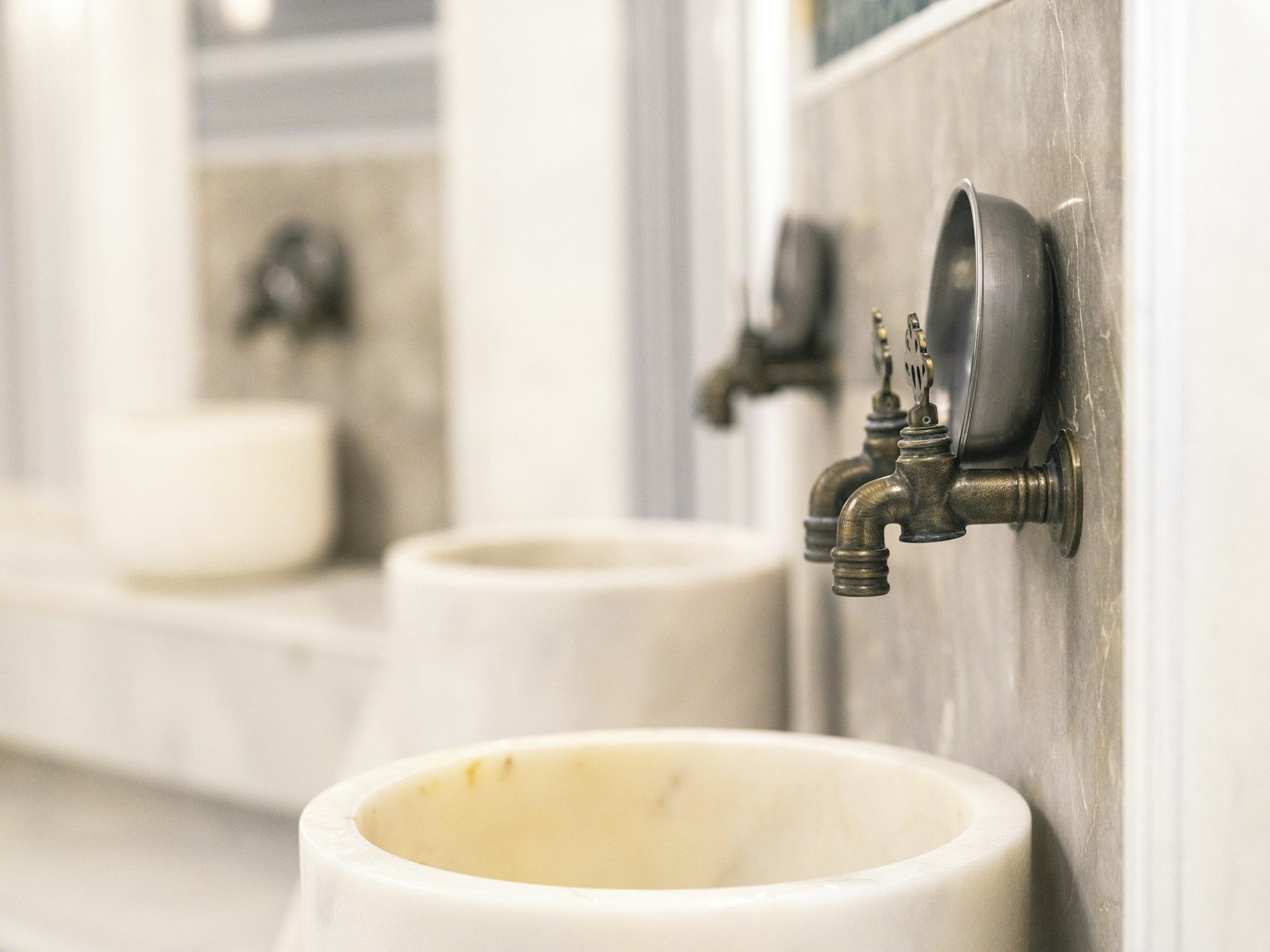 Marble basins and brass taps in a steam room