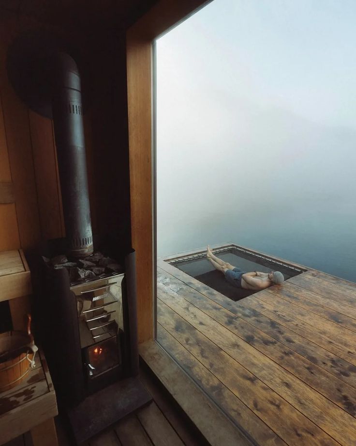 Stove beside a glass wall, a swimmer floating in the plunge outside