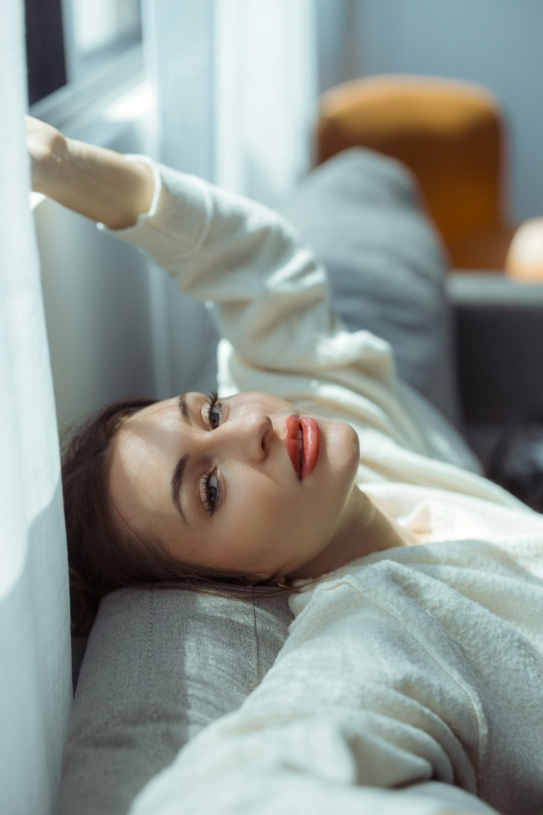 Woman resting on a pale bed
