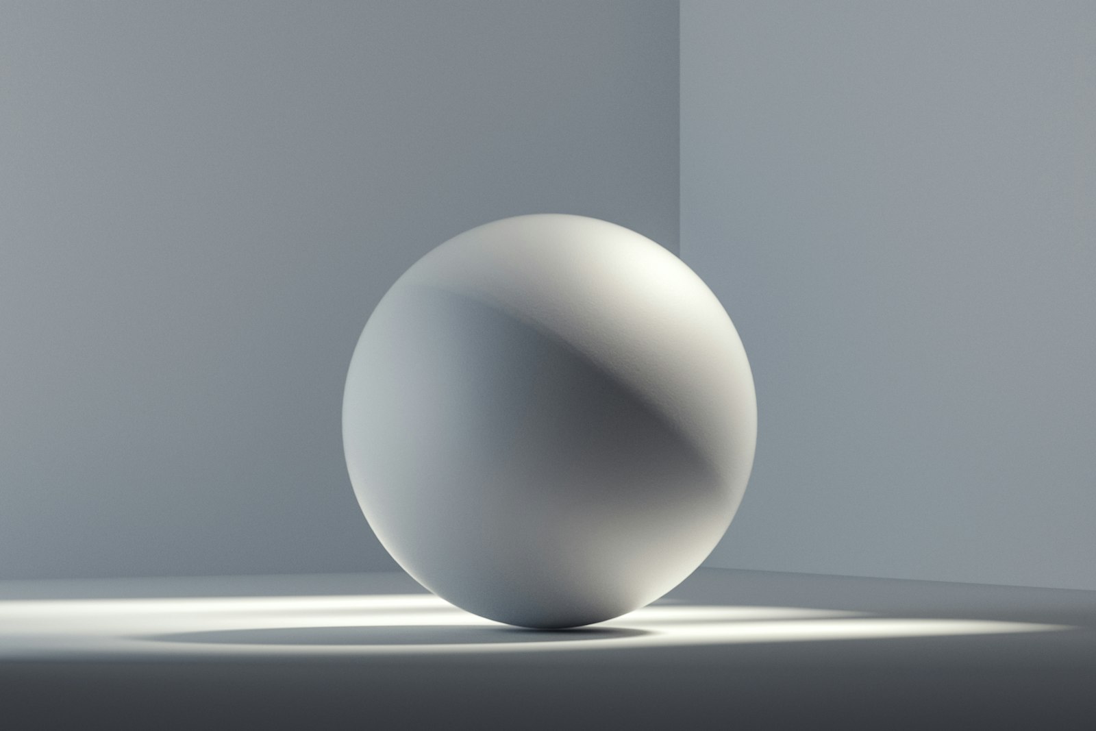 Pale sphere resting on a grey surface