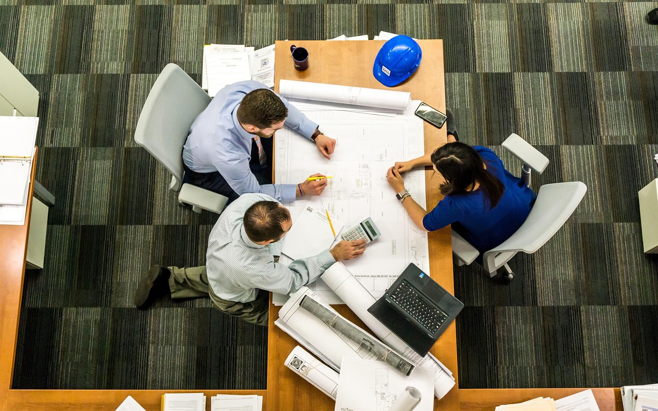 Four architects around a drawing table, seen from above