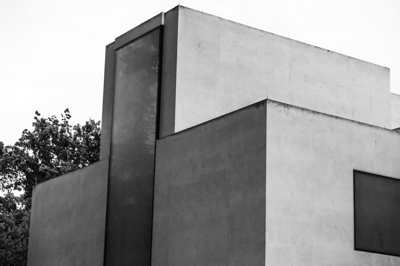 White concrete house volumes with trees