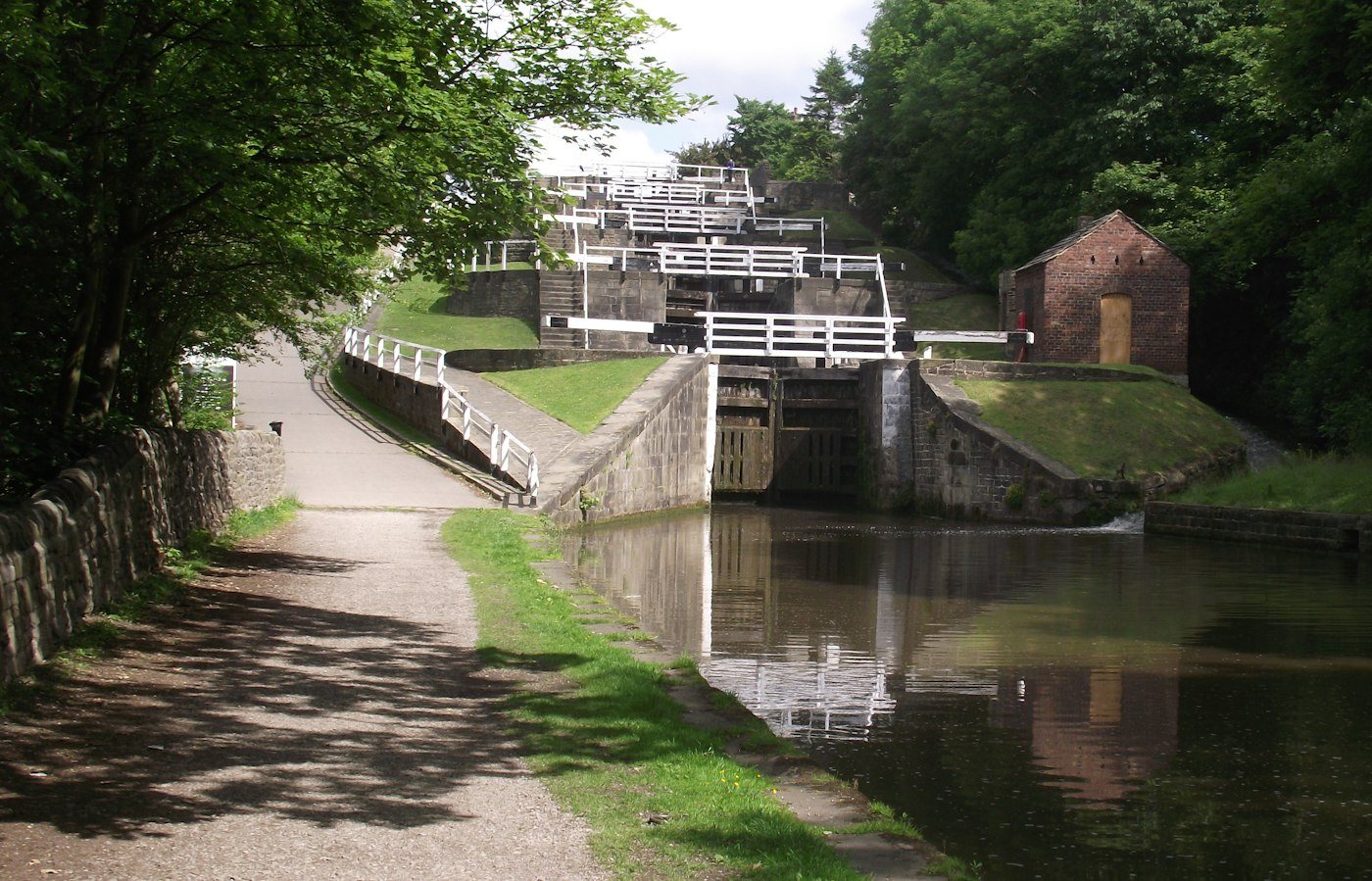 Looking up a flight from the towpath, a brick hut beside the chamber