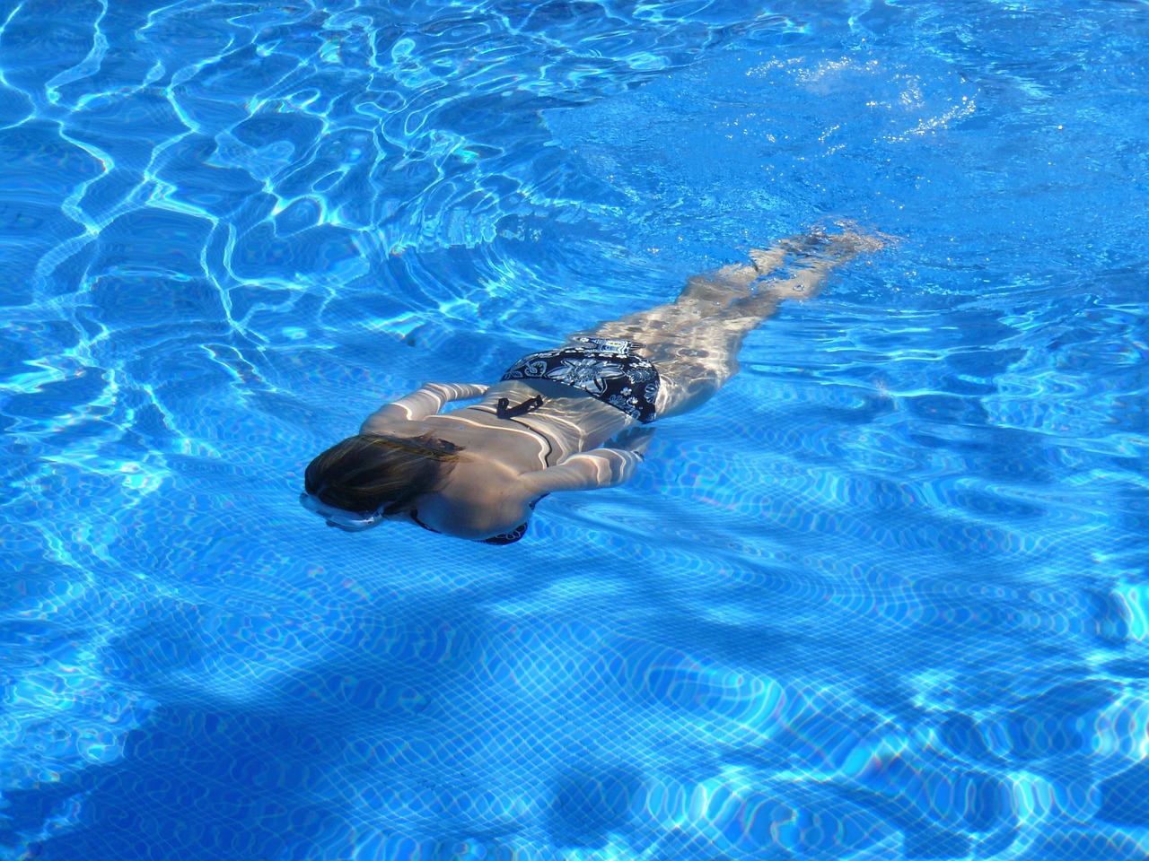 Swimmer in a blue pool, seen from above