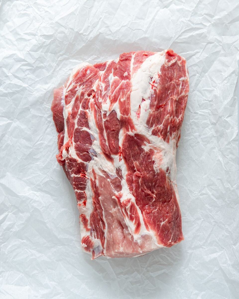 Raw boneless pork shoulder on white paper