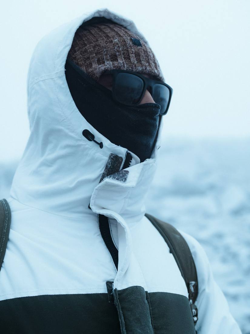 Hooded figure in a white jacket and balaclava
