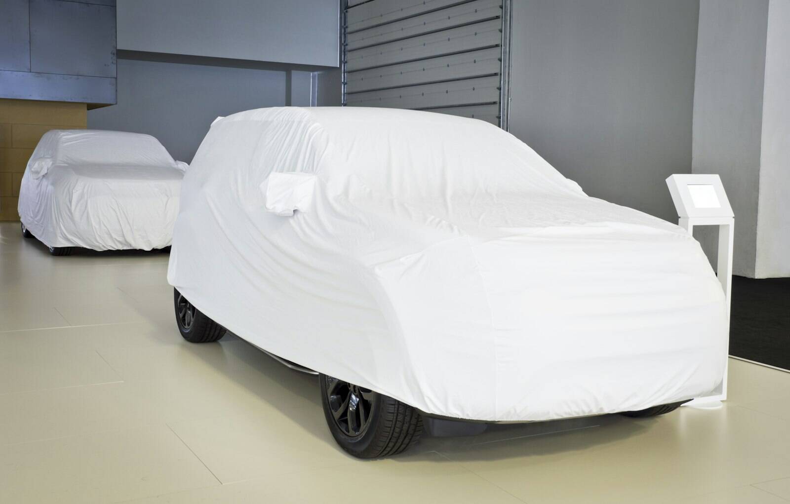 Covered cars in a bright showroom