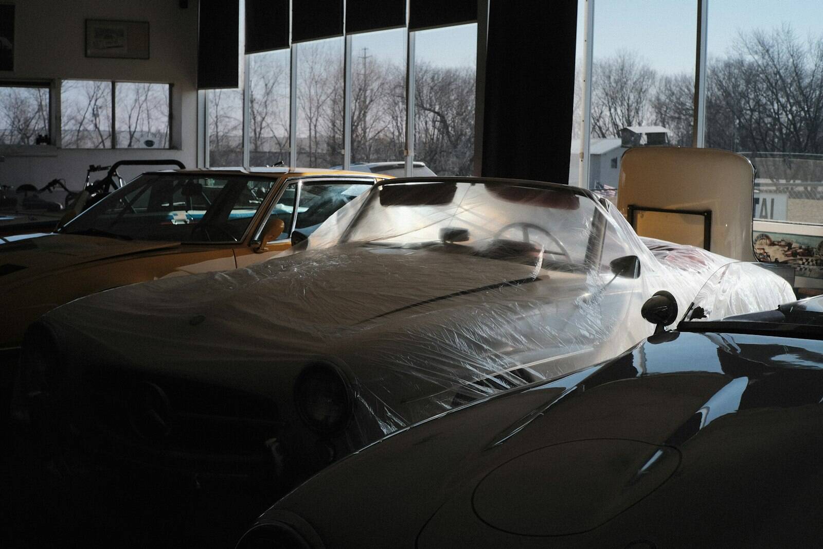 Covered cars in a dark workshop hall