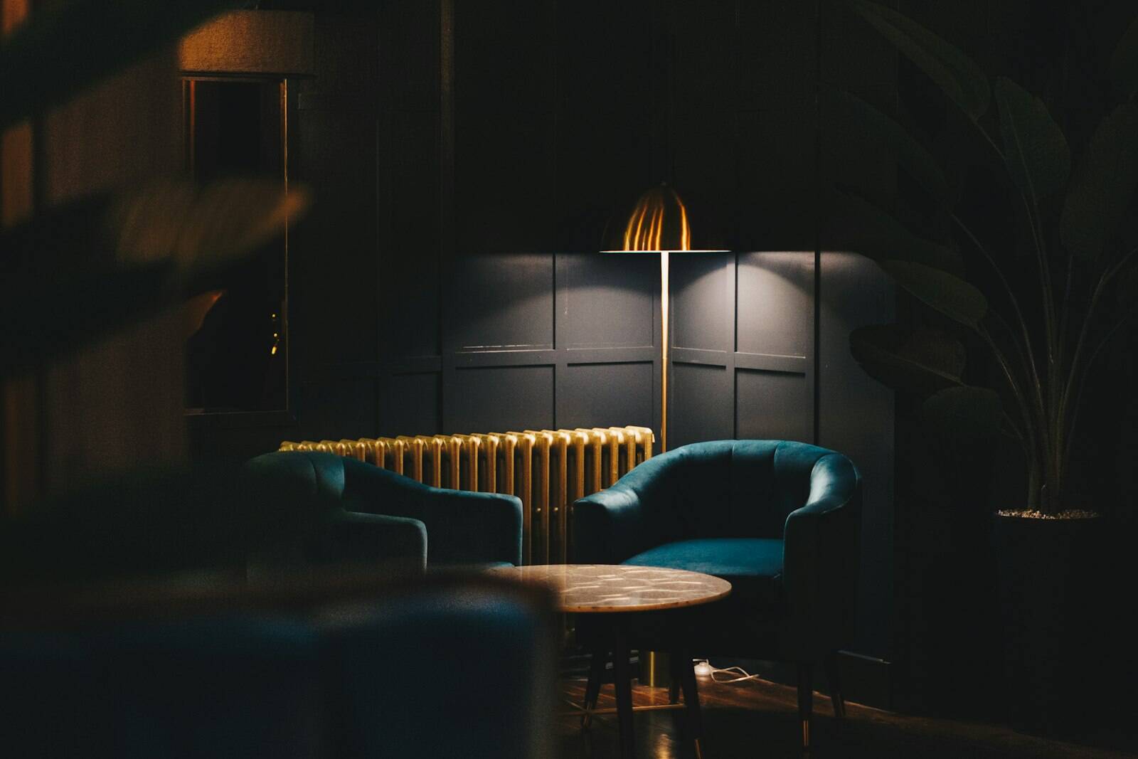 Lounge with armchairs and lamps in low light